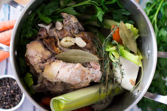 A closeup of chicken stock ingredients in a large pot.