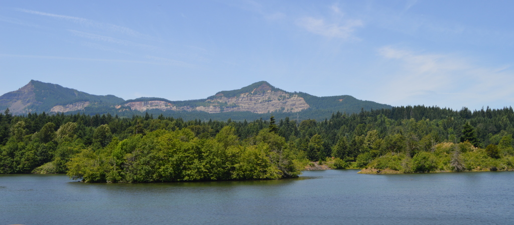 A body of water with a mountain in the background.