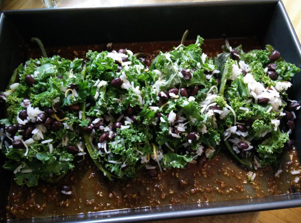 Kale-stuffed peppers in a baking dish.