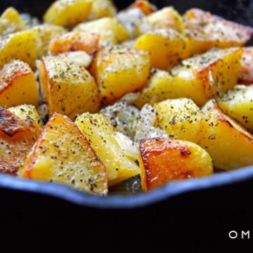 A closeup of home fries in a skillet.