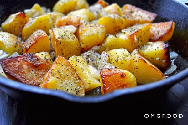 A closeup of home fries in a skillet.