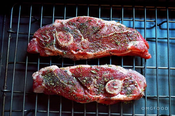 Seasoned lamb chops on a baking dish.