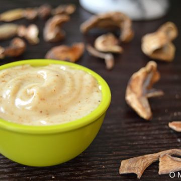 Closeup of umami mayo in a small bowl with dried mushrooms in the background.