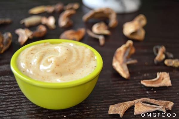 Closeup of umami mayo in a small bowl with dried mushrooms in the background.