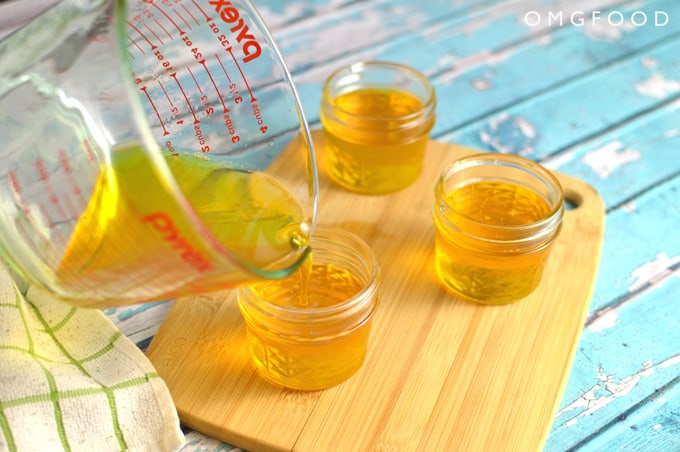 Ghee being poured into small mason jars.