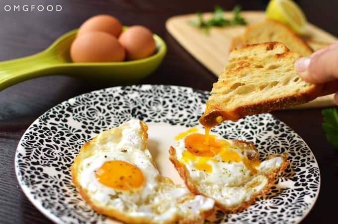 Toast dipping into a fried egg yolk.