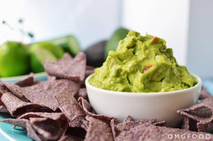 Closeup of guacamole in a bowl surrounded by chips.