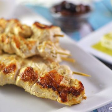 Closeup of chicken skewers on a plate.