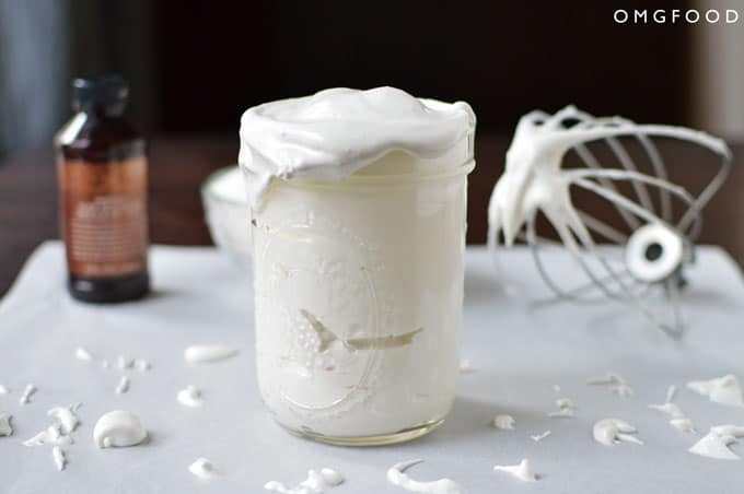 Marshmallow sauce in a glass mason jar on a tabletop.