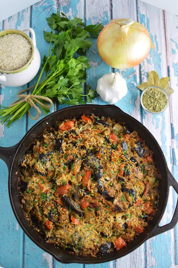 A skillet of eggplant and rice on a tabletop.