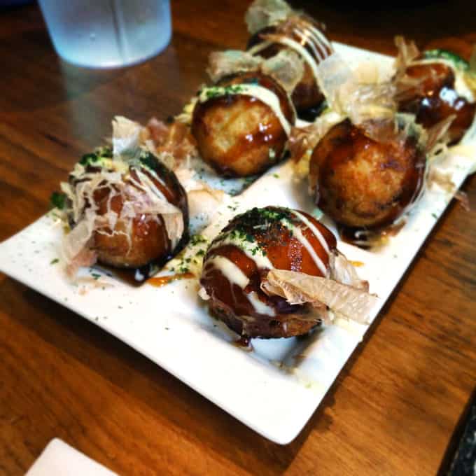 Closeup of takoyaki on a plate.