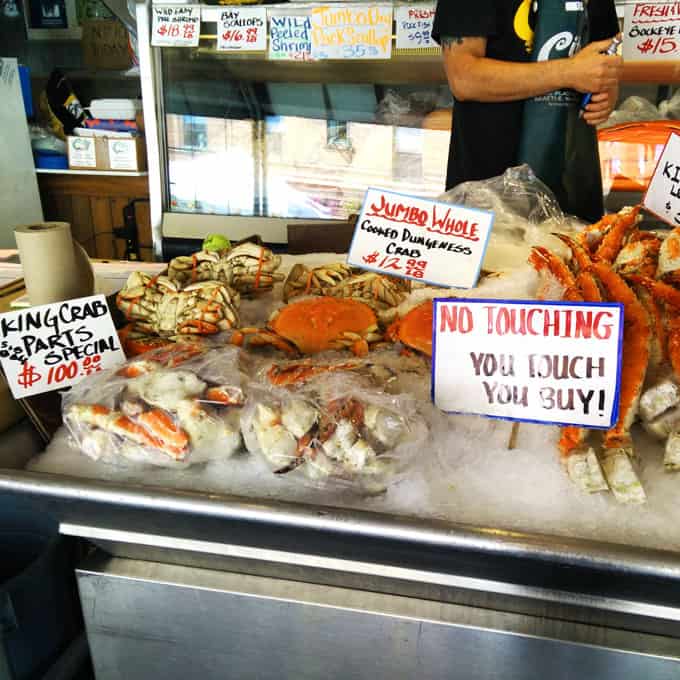 A seafood case at a store of various crabs.