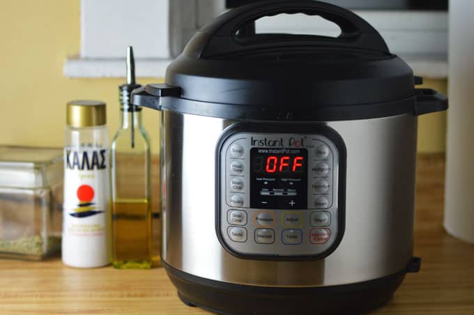 A pressure cooker next to a bottle of salt and oil.