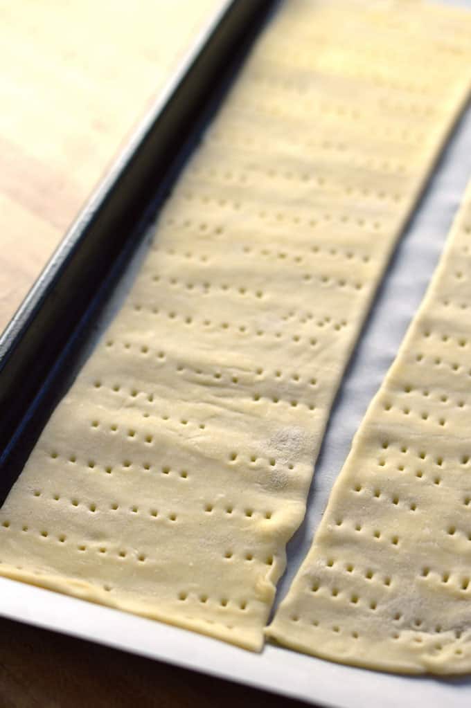 Puff pastry strips on a baking sheet.