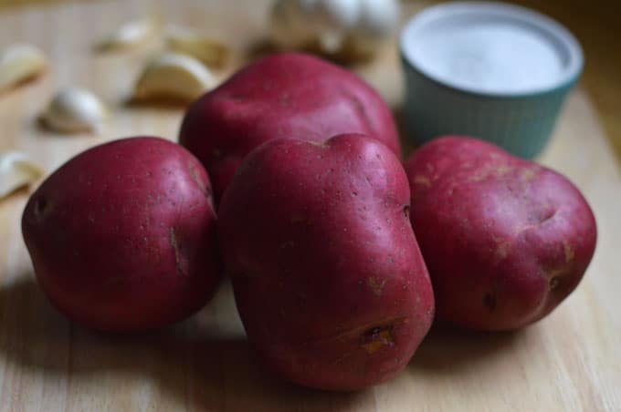 A closeup of red potatoes on a cutting board.