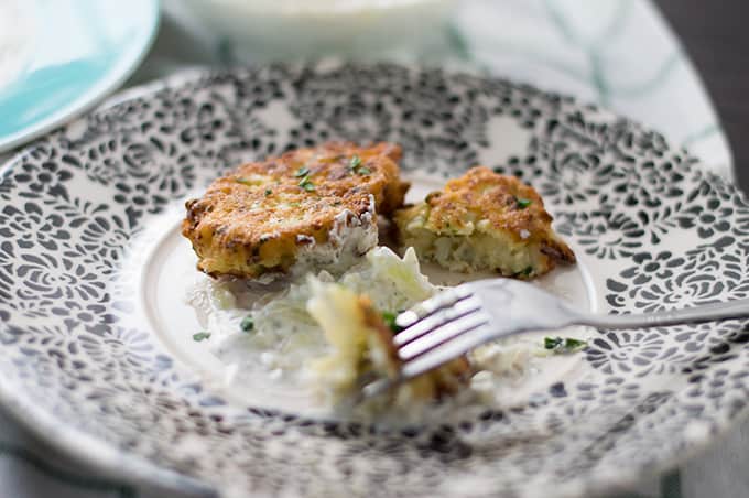 Cauliflower fritters on a plate with a fork.