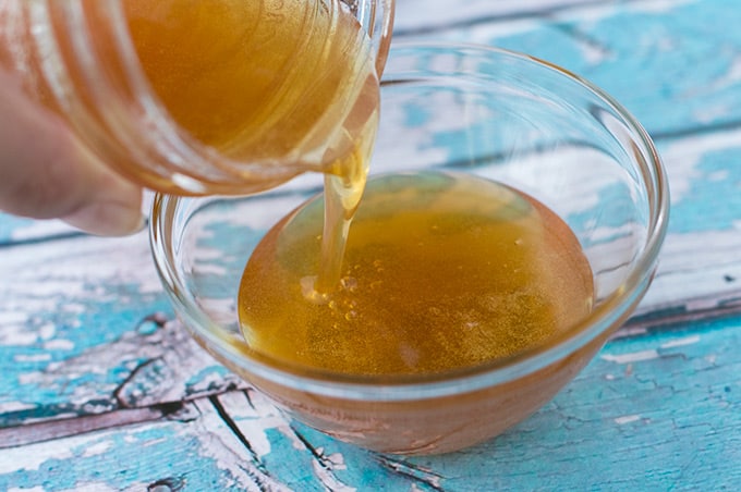 Honey being poured into a small bowl.