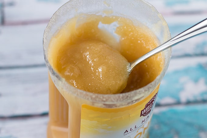 Close up of a spoon in a jar of crystallized honey.