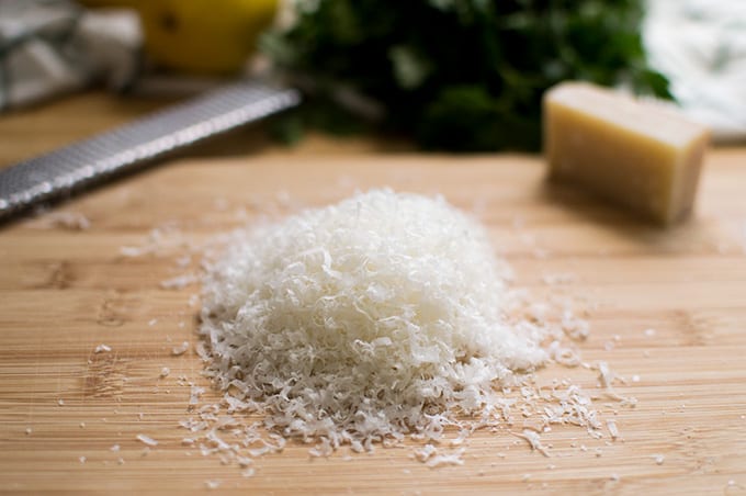 Grated parmesan cheese on a cutting board.