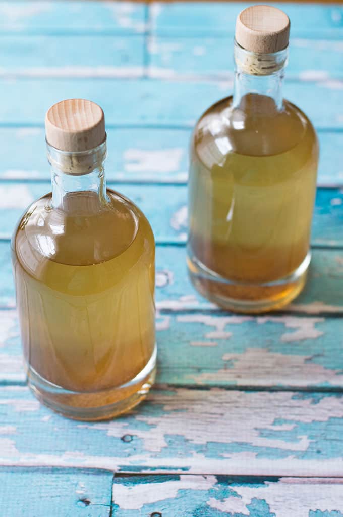 A close up of homemade gin in glass bottles.