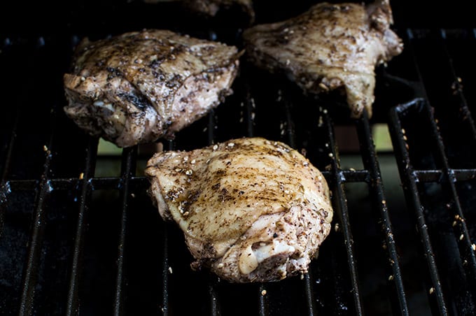 A close up of chicken cooking on a grill.