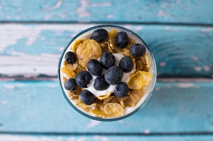 Closeup of blueberry yogurt parfait in a small glass bowl.