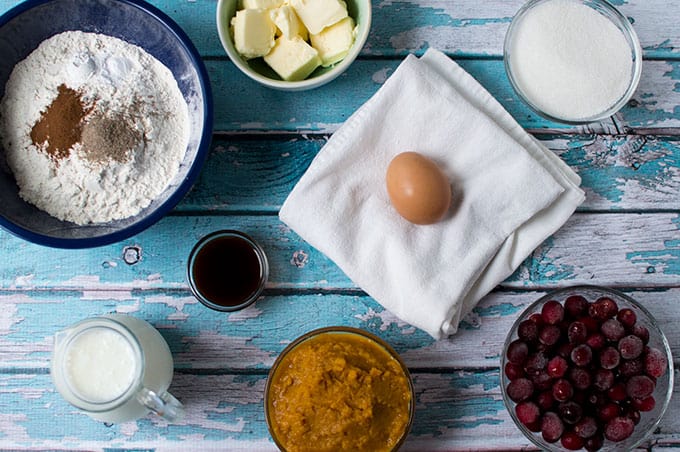 Ingredients to make pumpkin whoopie pies: flour, butter, egg, sugar, dried cranberries, pumpkin puree, milk, vanilla extract, and buttermilk.