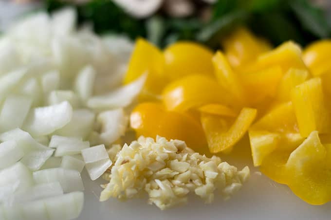 Close up of chopped onions, bell peppers, and garlic.