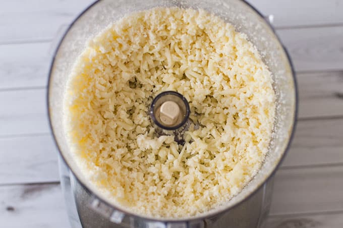 Close up of grated cheese in a food processor.