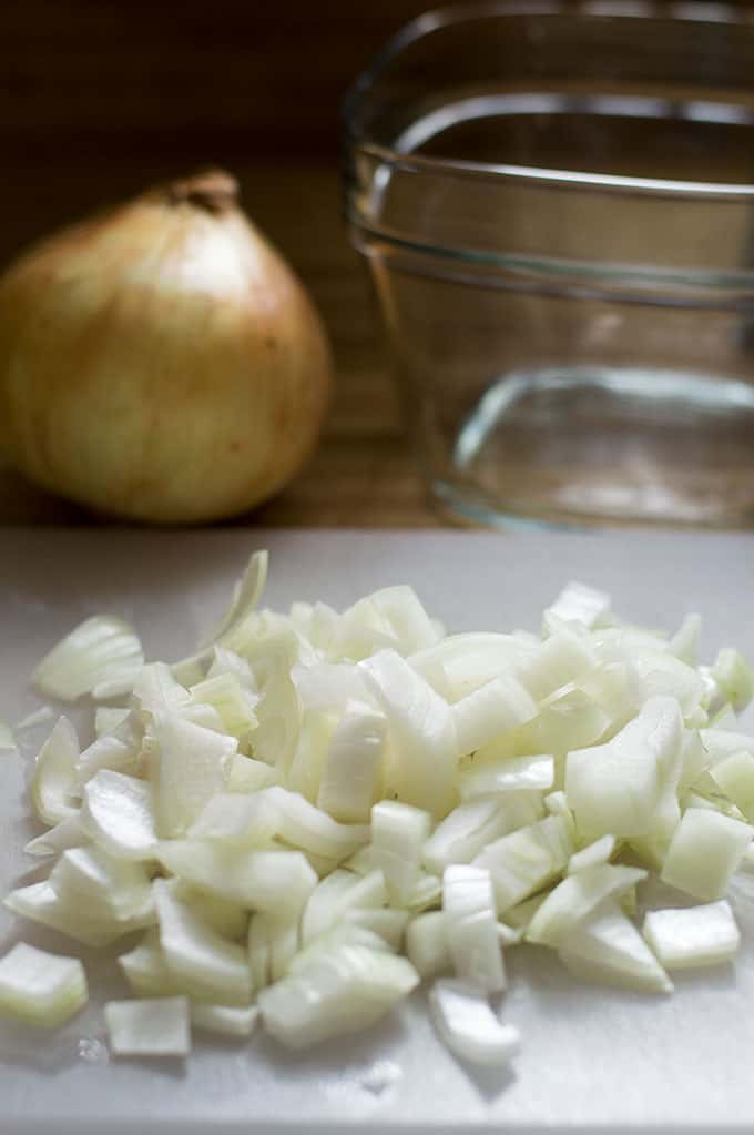 Close up of chopped onions on a cutting board.