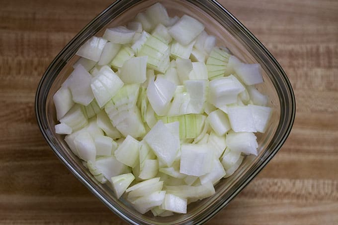 Close up of chopped onions in a glass food storage container.