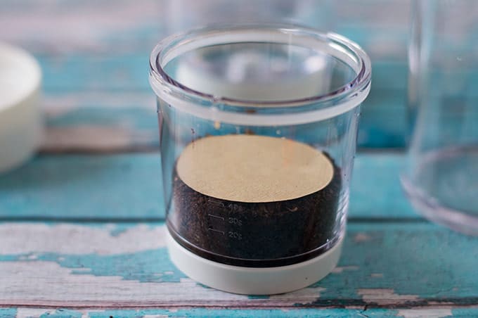 Cold brew maker filled with coffee grounds.