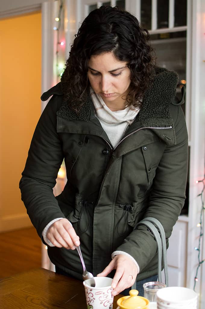 A woman preparing a cup of coffee.