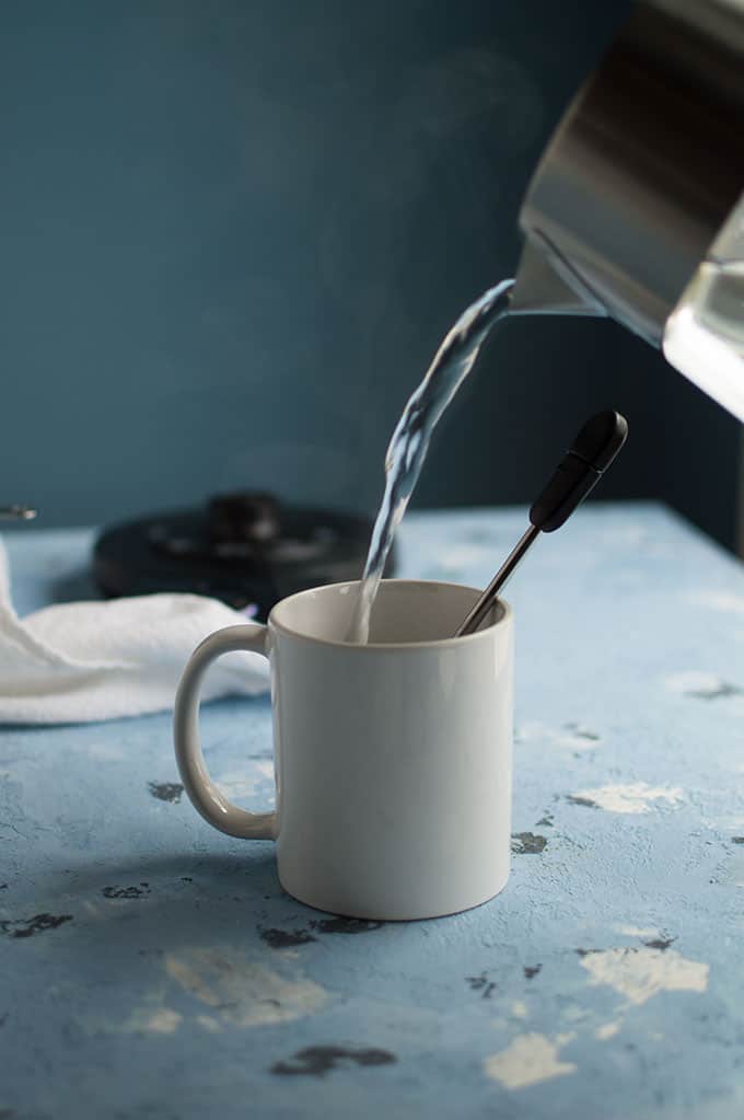 Hot water being poured into a mug.