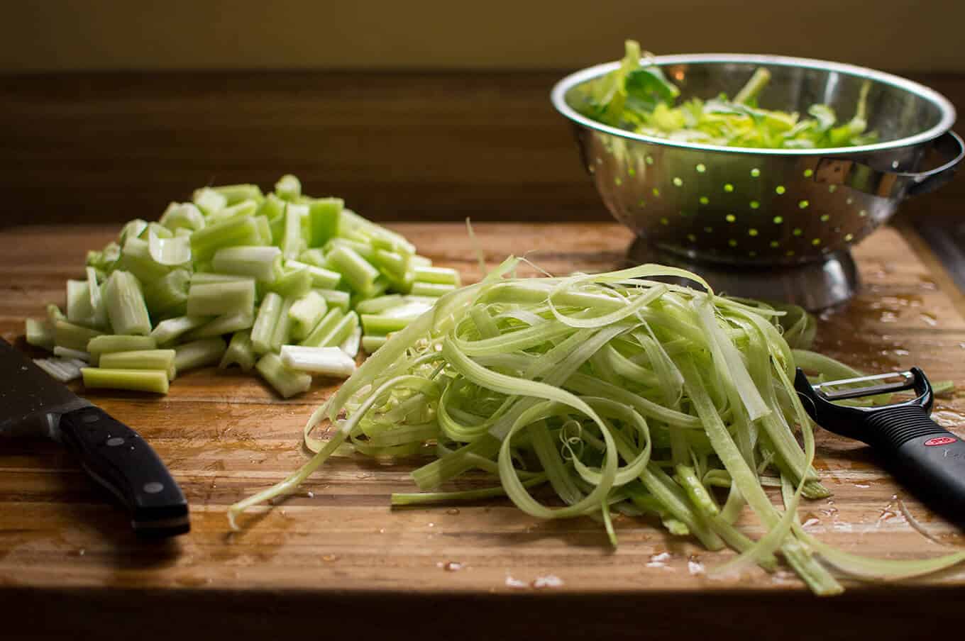 Chopped and peeled celery on a wooden cutting board.