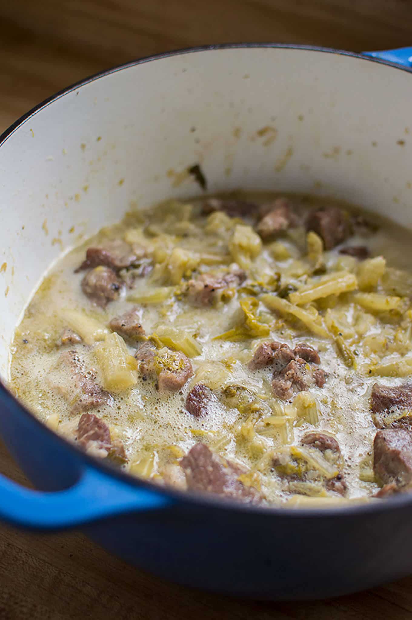 A dutch oven of pork and celery stew.