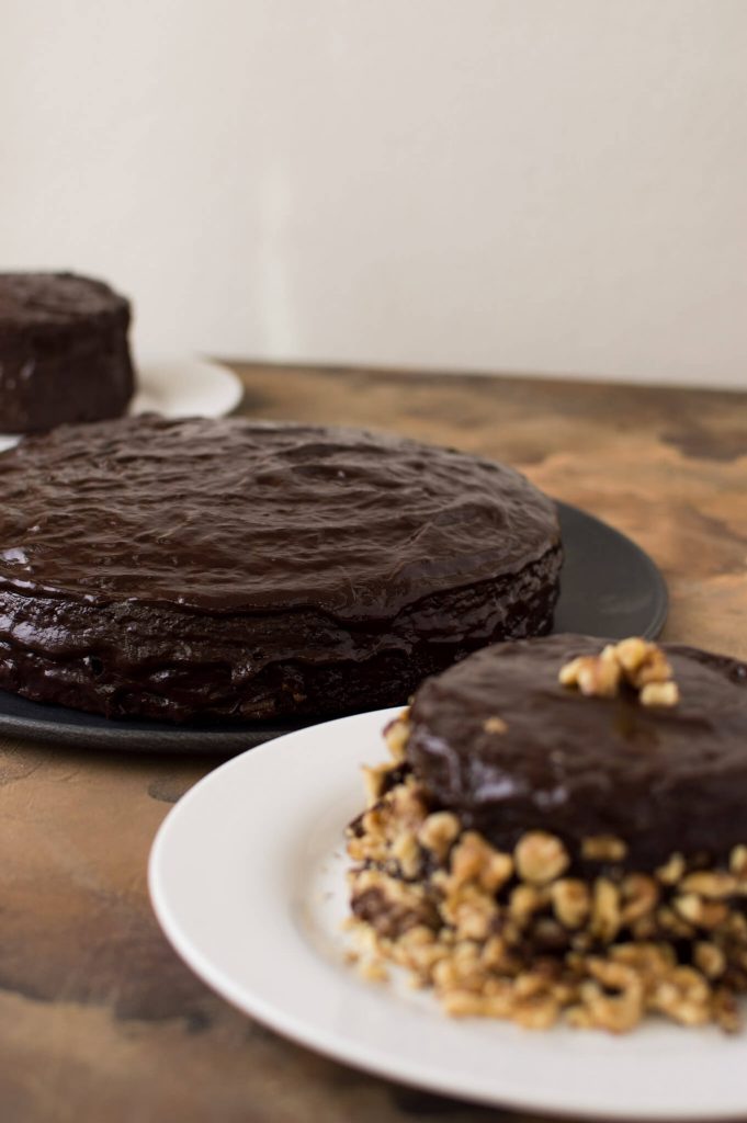 Various sized chocolate cakes on platters.