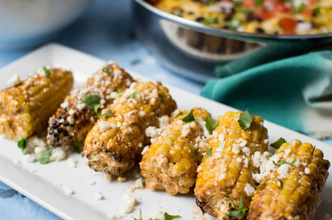 Close up of elotes on a plate.