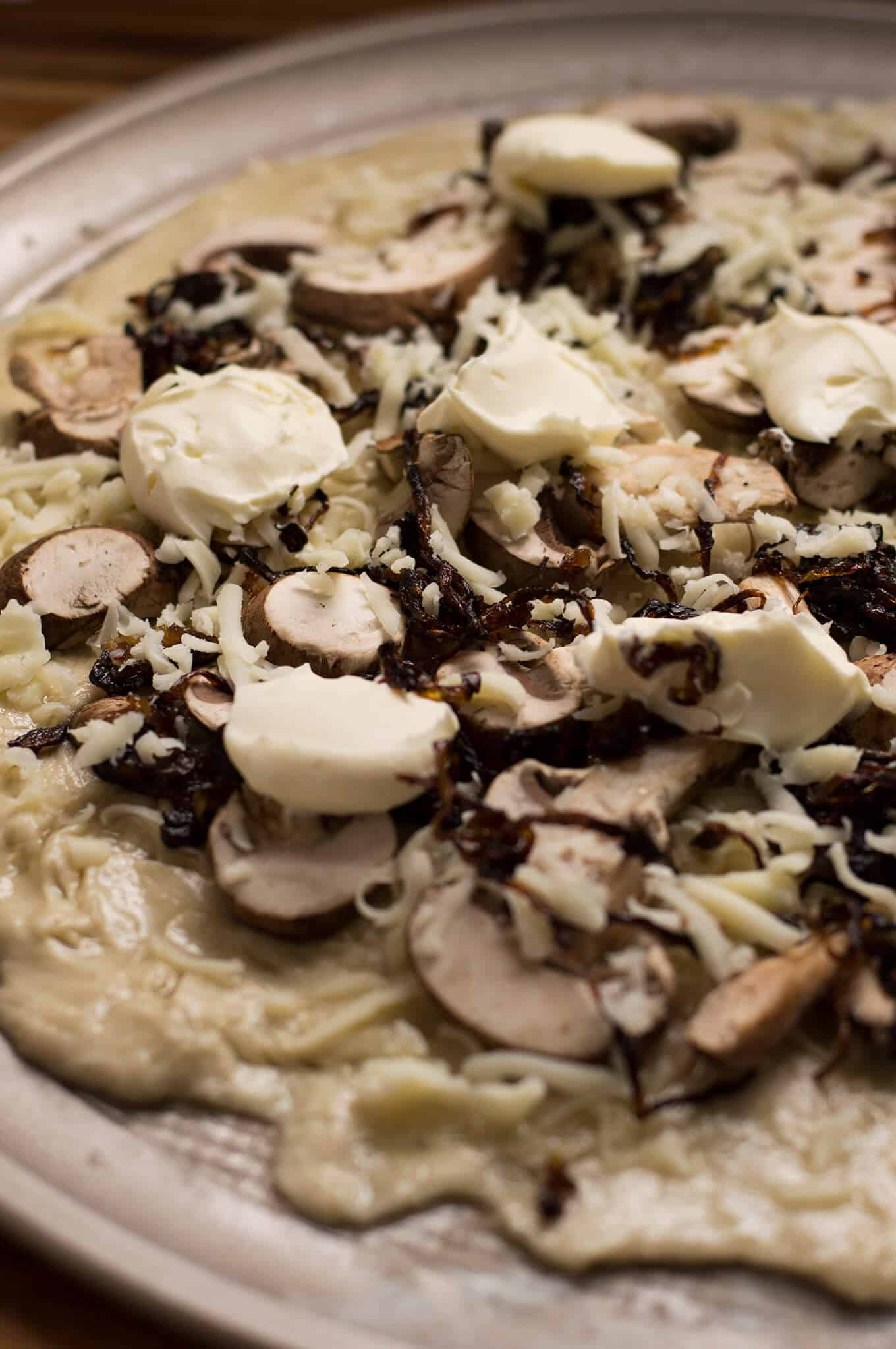 Prepared mushroom pizza on puff pastry dough.