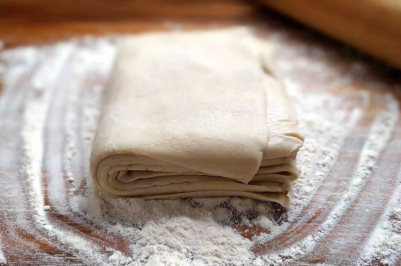 Puff pastry on a floured cutting board.