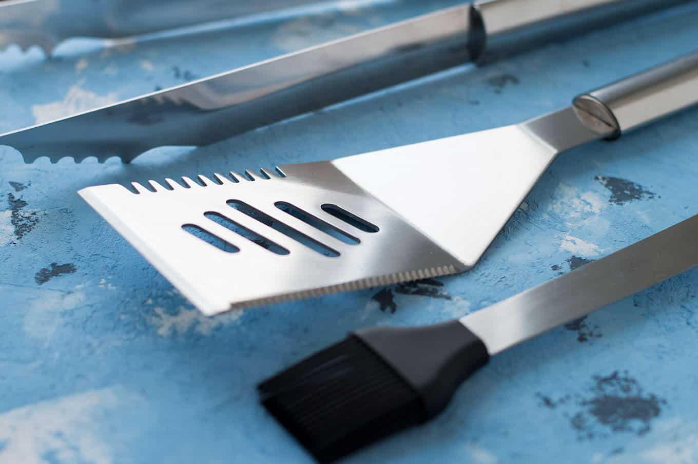 Closeup of grilling utensils on a table.