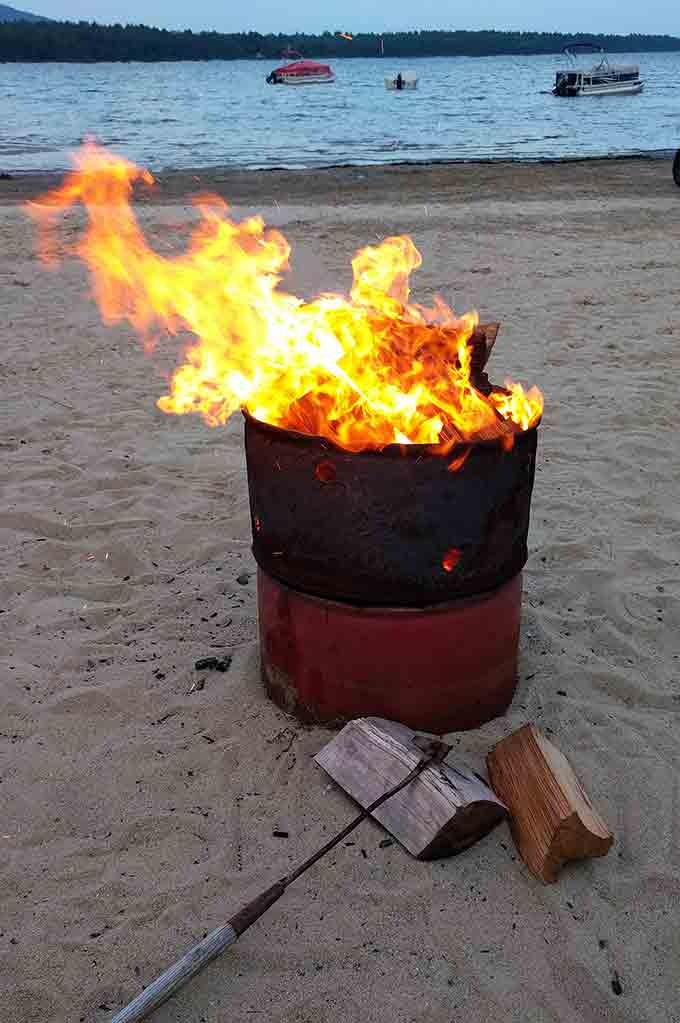 A fire barrel on a beach.