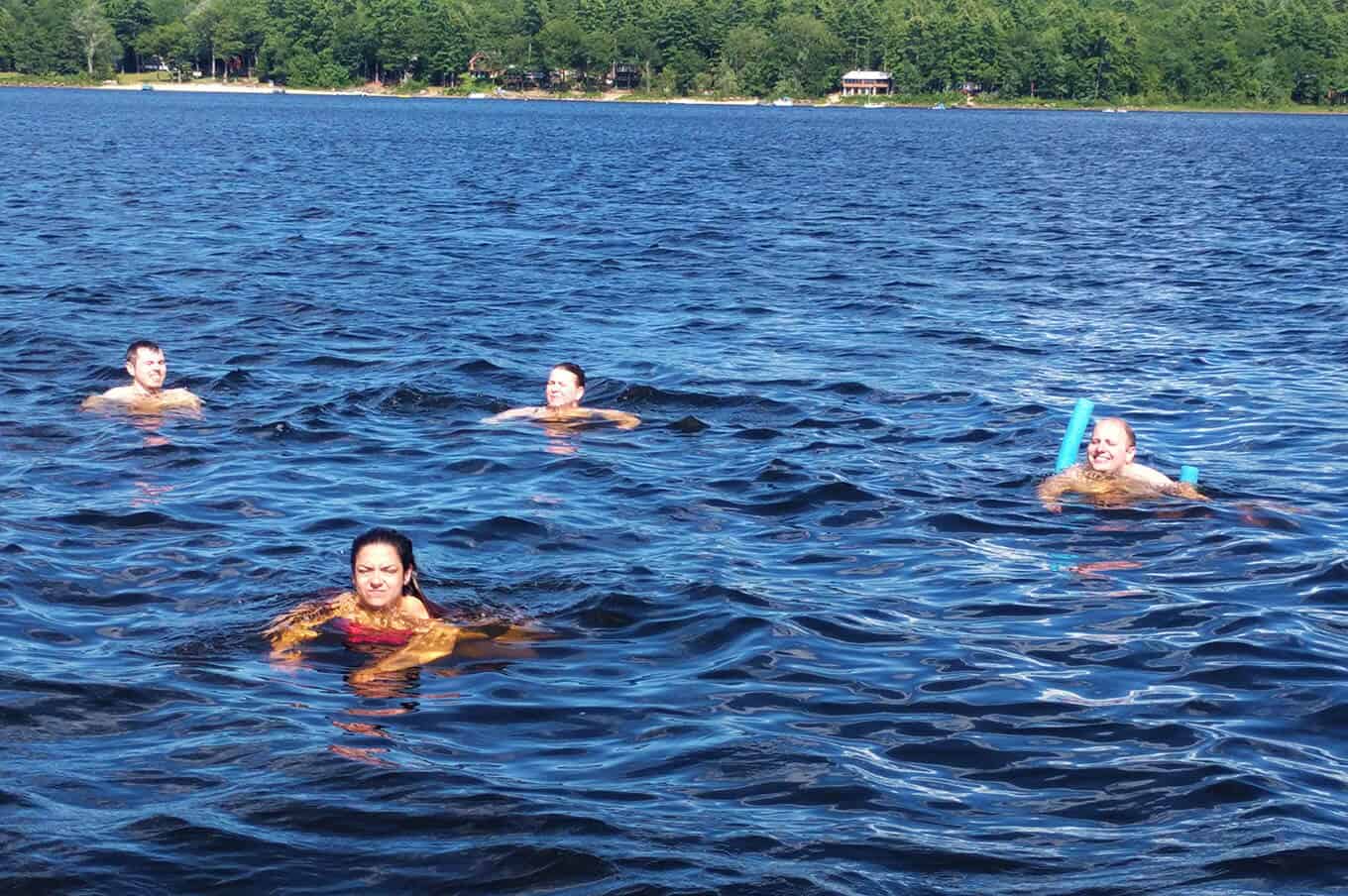 A group of people swimming in a lake.