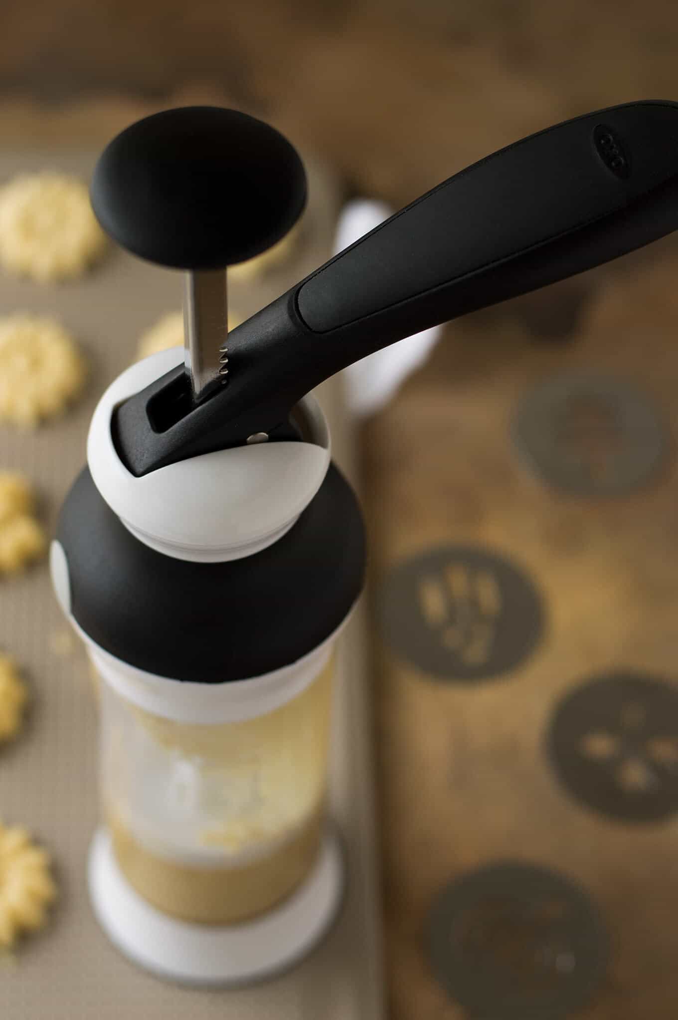 A cookie press filled with dough.