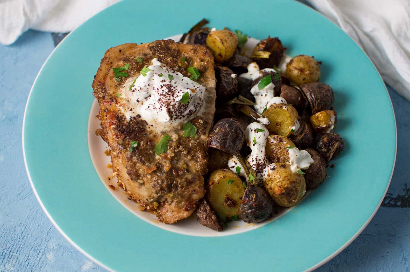 A plate of dukkah pork chops and roasted potatoes.