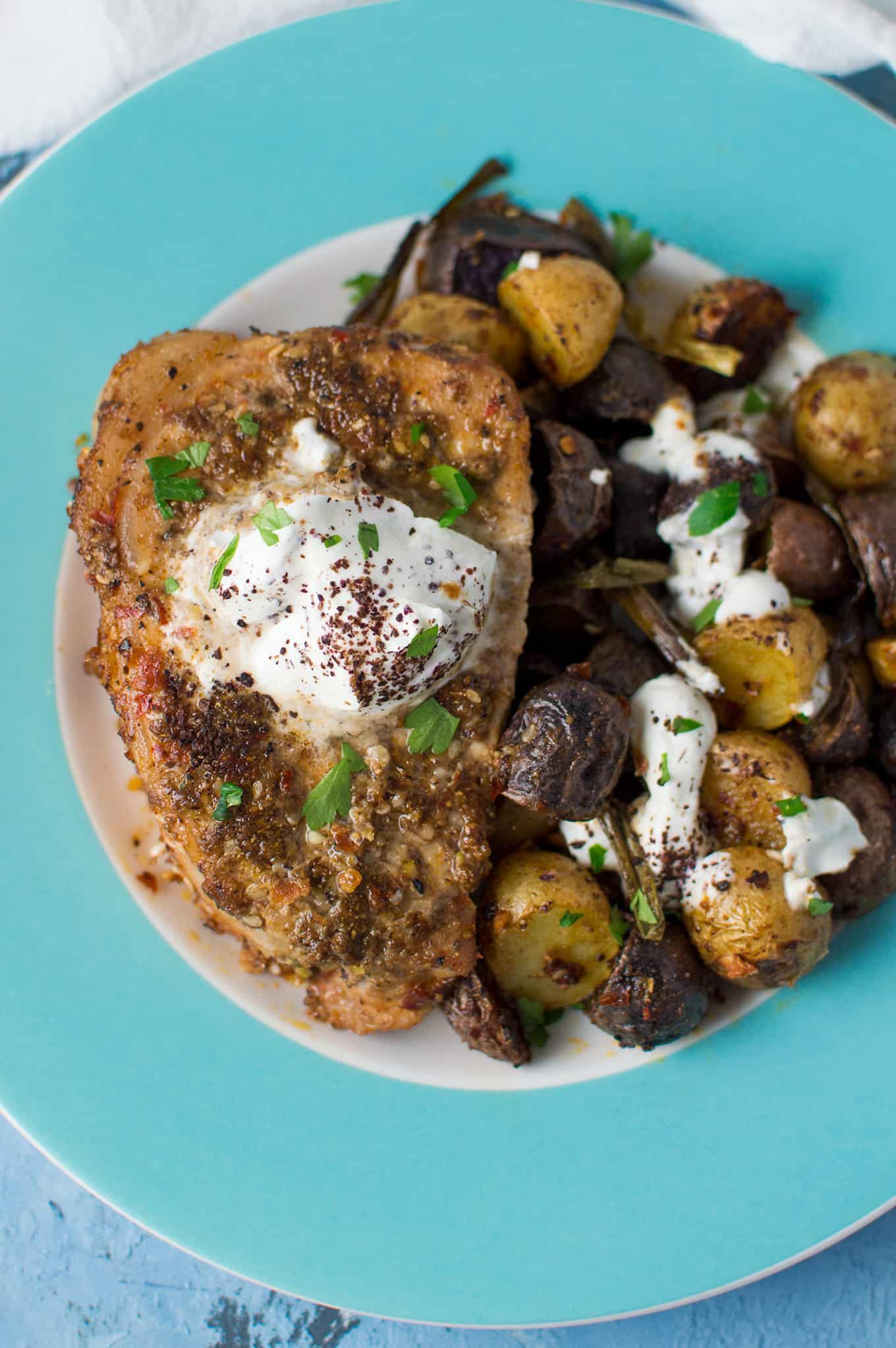 A plate of dukkah pork chops and roasted potatoes.