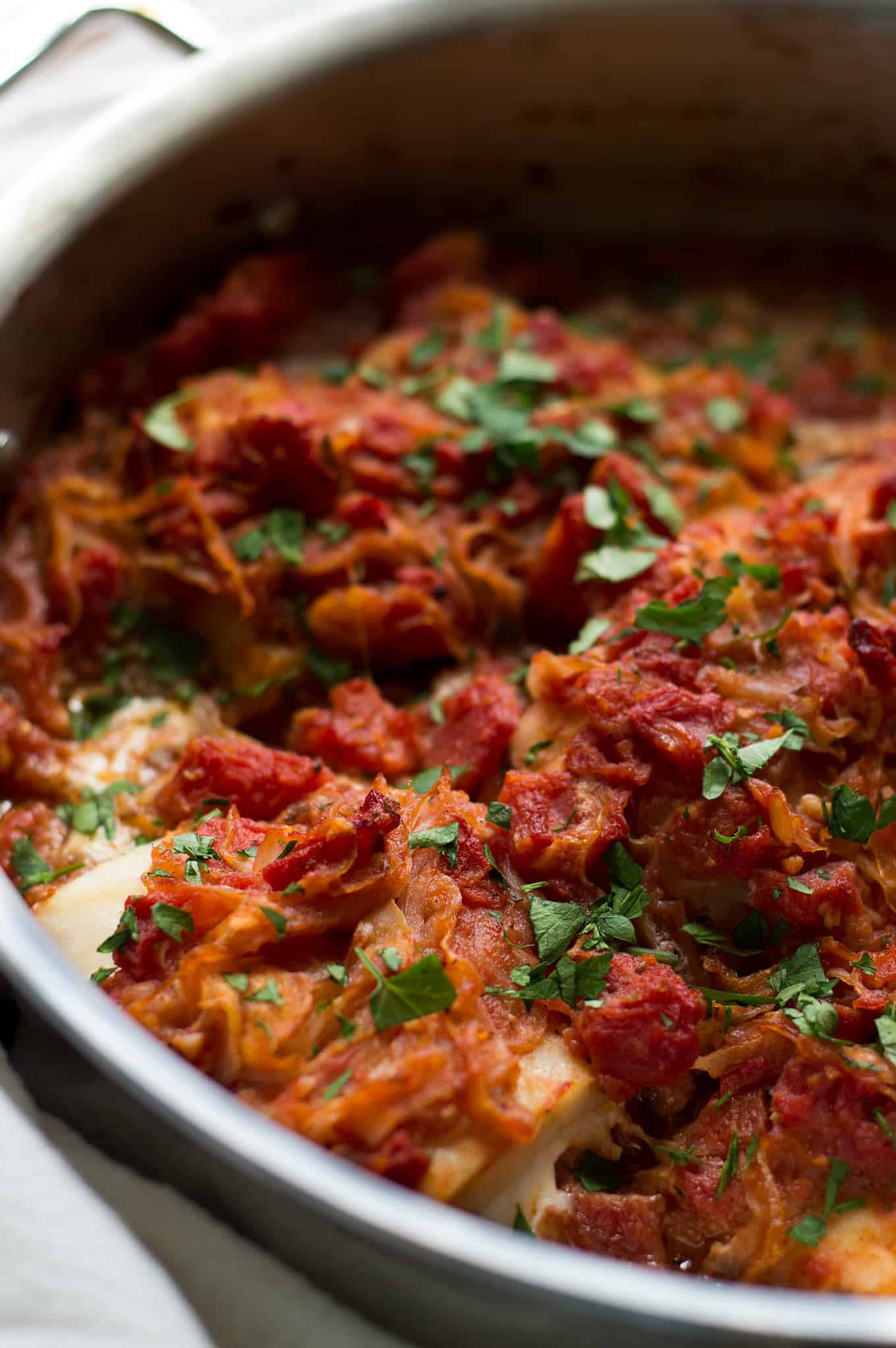 Close up of psari plaki in a stainless steel pan.