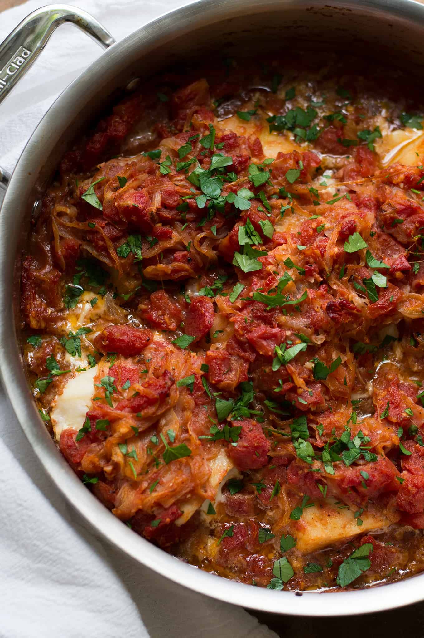 Close up of psari plaki in a stainless steel pan.