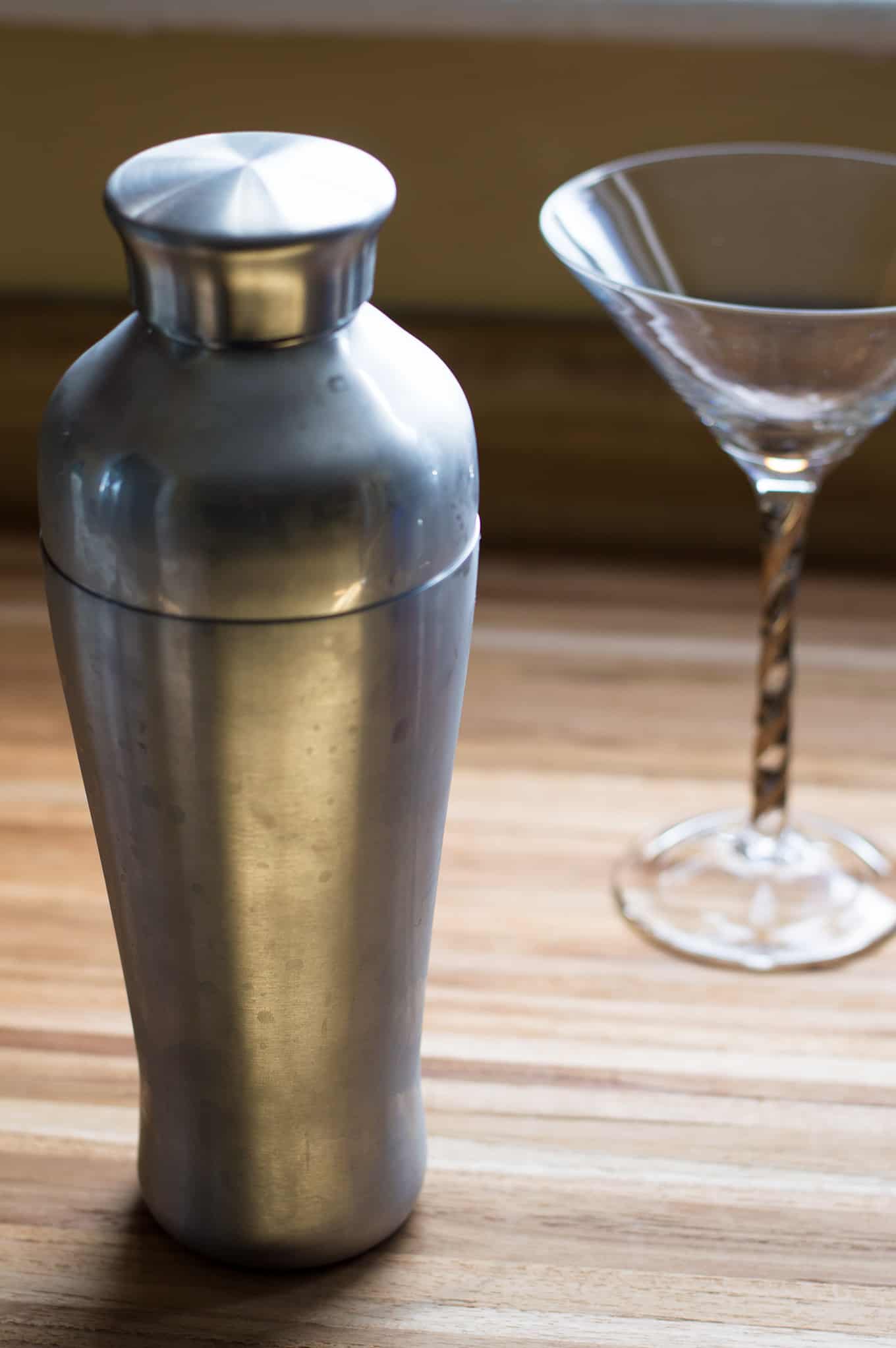 Close up of a cocktail shaker and martini glass.