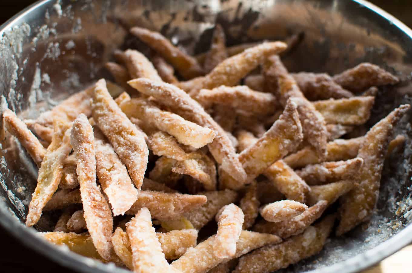 Cooked Trinidadian kurma coated in sugar in a stainless steel bowl.